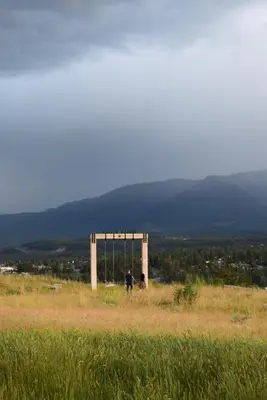 a man and a dog standing on a hill with a monument at Headwaters Lodge at Eagle Ranch Resort in Invermere