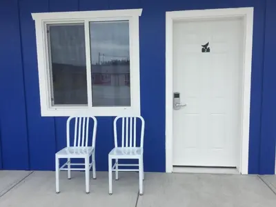 two chairs sitting in front of a door and a window at Humpback Inn in Port McNeill