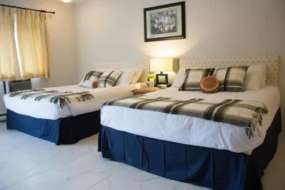 two beds sitting next to each other in a room at Christina Lake Motel and RV Park in Christina Lake
