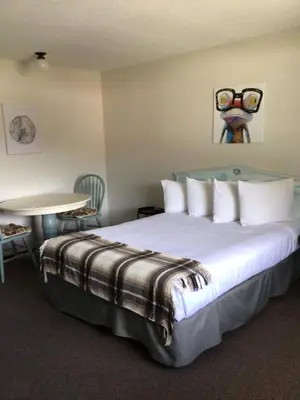 a hotel room with a bed and a table and a table at Christina Lake Motel and RV Park in Christina Lake
