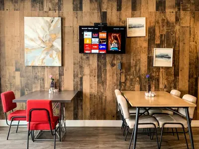 two tables in a restaurant with red chairs at 7 Day's Hotel in Lamont