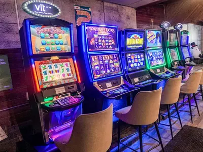 a row of slot machines in a room with chairs at 7 Day's Hotel in Lamont