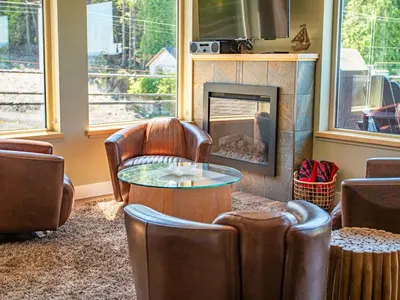 a living room with chairs and a fireplace at The Moorage in Ucluelet