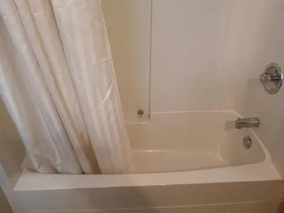 a white bath tub with a shower curtain at Ranchland Villa Motel in Merritt
