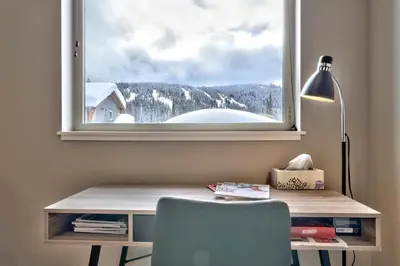 a desk with a chair and a window with a view at Echo Landing#02 By Bear Country in Sun Peaks