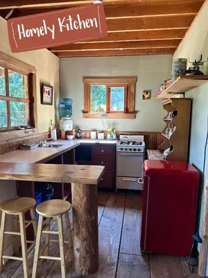 a kitchen with a wooden table and a red refrigerator at Maple Heart Ranch in Shawnigan Lake