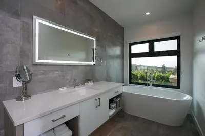 a bathroom with a sink and a tub and a window at The Inn at Therapy Vineyards in Naramata