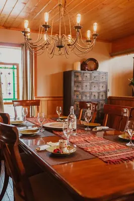 a dining room with a table with a chandelier at Ambleside Lodge Bed & Breakfast in Canmore