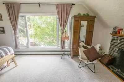 a bedroom with a large window and a chair at North House - Banff Mountain Home- The Real Rockies Experience in Banff