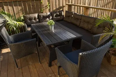 a wooden table and chairs and a couch on a patio at North House - Banff Mountain Home- The Real Rockies Experience in Banff