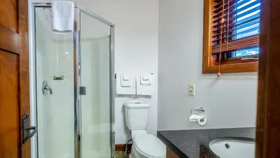 a bathroom with a toilet and a glass shower at Woodhaven #11 by Bear Country in Sun Peaks