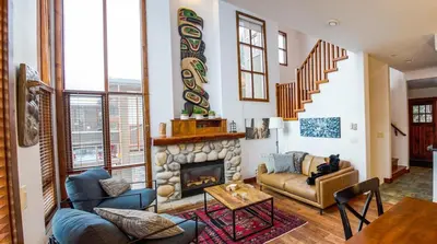 a living room with a fireplace and a couch at Woodhaven #11 by Bear Country in Sun Peaks