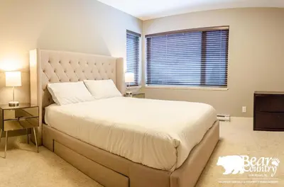 a bedroom with a large bed and a window at Echo Landing #12 by Bear Country in Sun Peaks