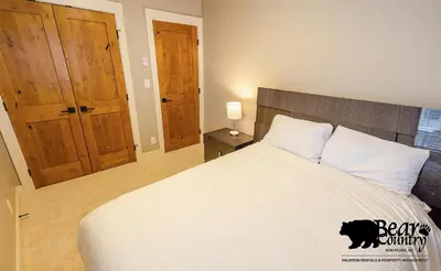 a bedroom with a bed with a black cat on it at Echo Landing #12 by Bear Country in Sun Peaks