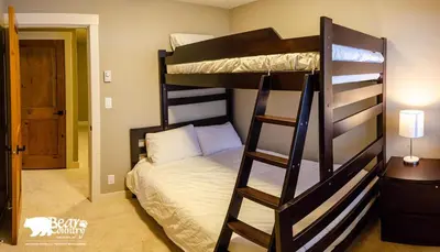a bedroom with two bunk beds and a ladder at Echo Landing #12 by Bear Country in Sun Peaks