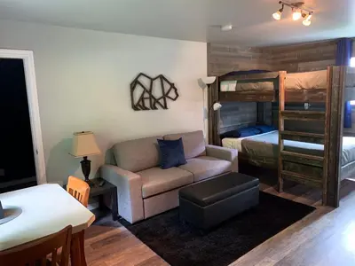 a living room with a couch and a bunk bed at Peaks Lodge in Revelstoke