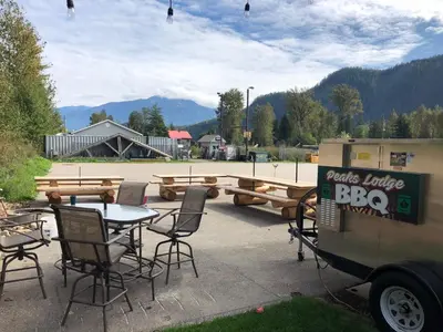 a patio with a table and chairs and a bbq at Peaks Lodge in Revelstoke