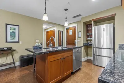 a kitchen with a refrigerator and a counter top at Sophisticated MTN 2 Bedroom Pool Hot Tub managed by Little Sister Getaways in Canmore