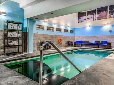 a swimming pool in a room with a couch and a couch at Sophisticated MTN 2 Bedroom Pool Hot Tub managed by Little Sister Getaways in Canmore