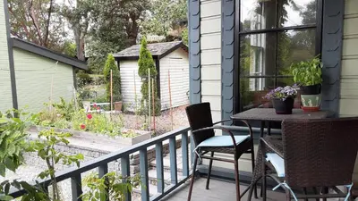 a balcony with a table and chairs and a garden at Sea Birds Cottage in Victoria