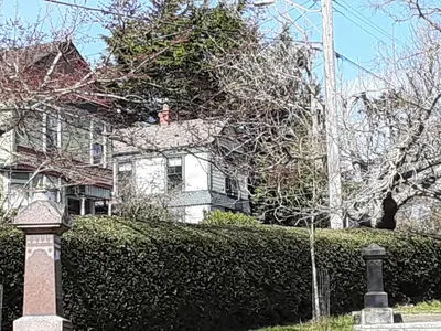 a house with a hedge in front of a house at Sea Birds Cottage in Victoria