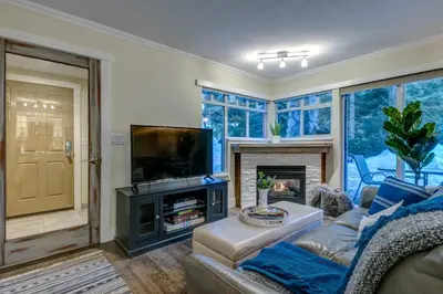 a living room with a couch and a tv and a fireplace at Sunpath Retreat- Convenience Meets Comfort & Style in Whistler