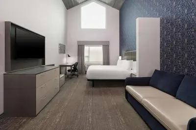 a hotel room with a couch and a bed and a television at Best Western Plus Prince George in Prince George