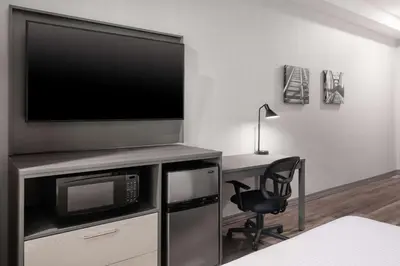 a living room with a tv and a desk with a chair at Best Western Plus Prince George in Prince George