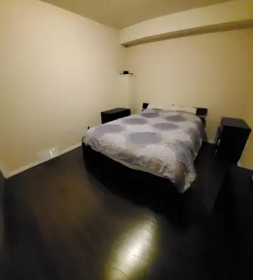 a bedroom with a bed and a wooden floor at Parson Creek Retreat in Fort McMurray