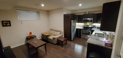 a living room with a couch and a kitchen at Parson Creek Retreat in Fort McMurray