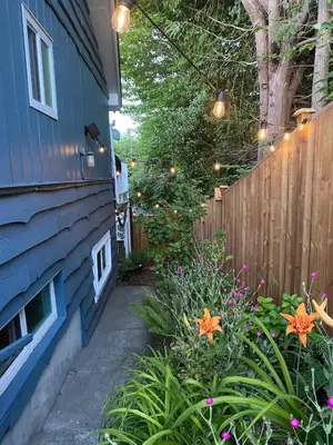 a backyard with a fence and a garden with flowers at The Wayward Inn in Chemainus