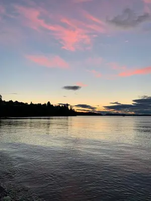 a sunset over a body of water with clouds at The Wayward Inn in Chemainus