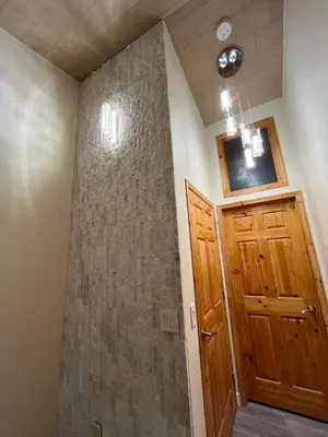 a bathroom with a shower with a wooden door at Banff Woods lodge in Canmore