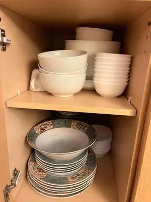 a cabinet filled with plates and bowls and plates on shelves at Banff Woods lodge in Canmore