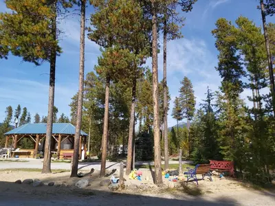 a park with a bench and a gazebo and trees at Blue River Campgrounds & Cabin-public washroom in Blue River