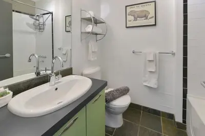 a white bathroom with a sink and a toilet at Harbourview Executive Condo by EMR Vacation Rentals in Victoria