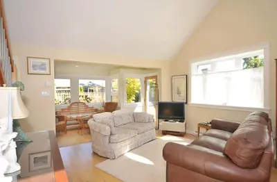a living room with a couch and chairs and a television at Heron View Cottage by EMR Vacation Rentals in Sidney
