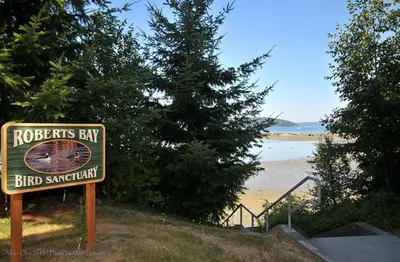 a sign for a roberts ray bird sanctuary next to a beach at Heron View Cottage by EMR Vacation Rentals in Sidney
