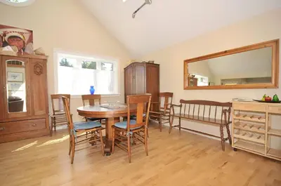 a dining room with a table and chairs and a mirror at Heron View Cottage by EMR Vacation Rentals in Sidney