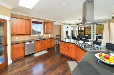 a large kitchen with wooden cabinets and a counter top at Nature's Gate Executive Estate by EMR Vacation Rentals in Victoria