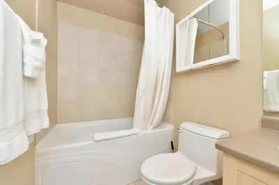a white bathroom with a toilet and a sink at Nature's Gate Executive Estate by EMR Vacation Rentals in Victoria