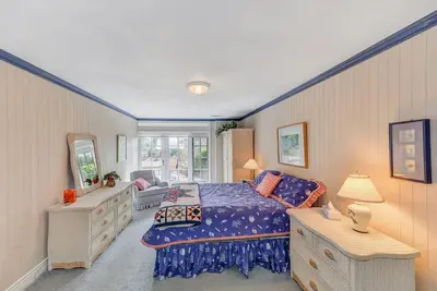 a bedroom with a bed and a dresser and a mirror at Oceanside Lodge Saanich Inlet by EMR Vacation Rentals in North Saanich