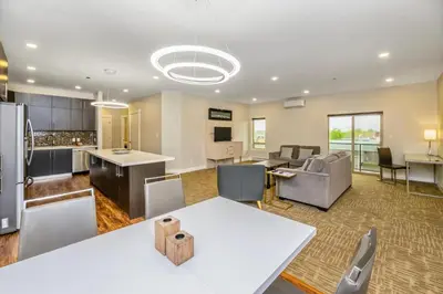 a large kitchen and living room with a white table at Quality Inn Sunshine Suites in Terrace