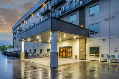 a building with a parking lot with tables and chairs at Quality Inn Sunshine Suites in Terrace