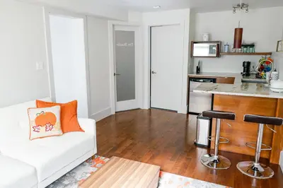 a living room with a white couch and a kitchen at Studio on Capri in Calgary