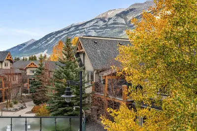 a house with a mountain in the background at Copperstone Resort in Dead Man's Flats