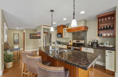 a kitchen with a large island in a room at Sunset Ridge - Luxurious Corner Condo - Spectacular Mt Views with open Pool! in Canmore