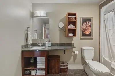 a bathroom with a sink and a toilet at Sunset Ridge - Luxurious Corner Condo - Spectacular Mt Views with open Pool! in Canmore