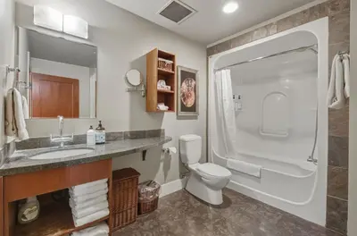 a bathroom with a toilet and a sink and a shower at Sunset Ridge - Luxurious Corner Condo - Spectacular Mt Views with open Pool! in Canmore