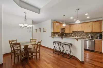 a kitchen and dining room with a table and chairs at Beautiful Peak Vista - 2BR w Stunning Mt Views in Canmore